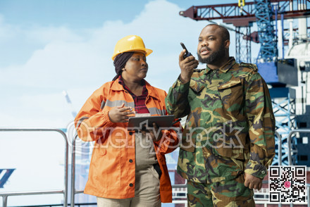 Soldier does escort duty for offshore platform, talking in handheld radio device photo 3214871