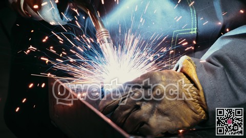 Close-up of a blacksmith welder working with metal using a welding machine, bright sparks and flashes in slow motion