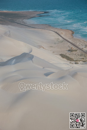 Quiet coastal sands from above. Remote aerial perspective of peaceful sandy coast and gentle waves