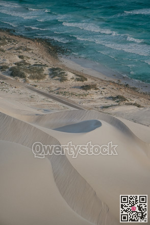 Textures of shoreline sand and ridges. Intricate sand formations near water with shadow and muted colors