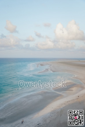Overhead perspective capturing peaceful blue waters merging with pristine white sandy beaches and soft ripples