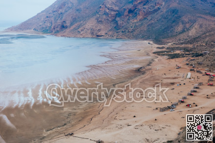 Seaside adventure scene. Coastal landscape with vehicles. Shoreline featuring vehicles and rugged mountains