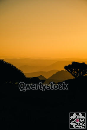 Amber evening light softly shades distant valleys creating serene and captivating backdrop