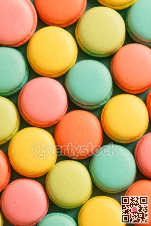 Assorted pastel macarons meticulously organized in grid to enhance festive and promotional visuals