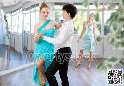 Pair dances - girl and boy in festive attire dance waltz in studio