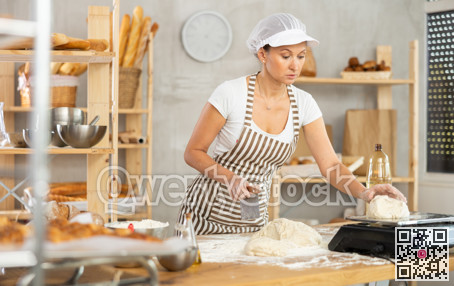Woman baker cuts and weighs pieces of dough