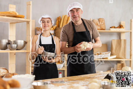 Male baker holding dough and teenage girl whipping in bowl