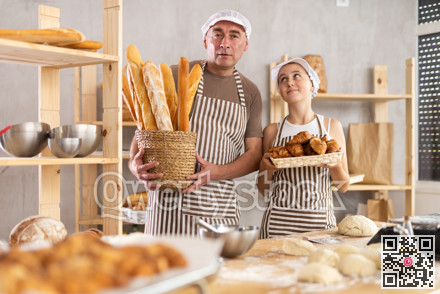 Teenage girl and male baker holding bakery products