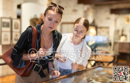 Woman and teenage girl looking at exhibit in museum display