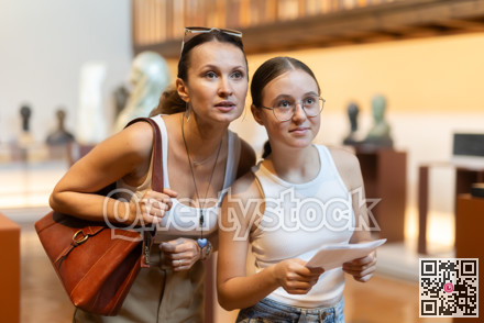 Young woman with teen daughter walk around museum, view sculpture in museum hall