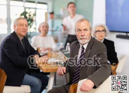 Girl with remote controller tell material, speaks to mature precursors of business group