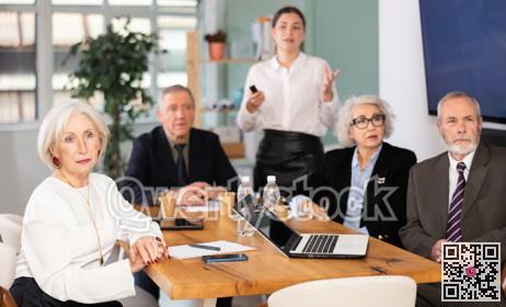 Young employee gives presentation to senior managers in office