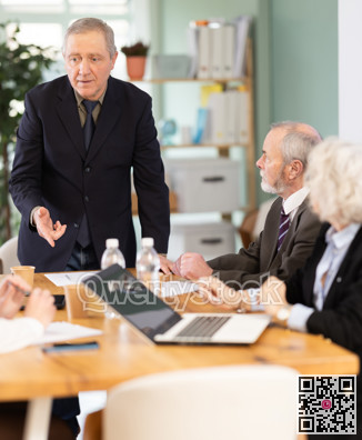 Male leader, trainer talking to group of people, brainstorming, discussing ideas in auditory