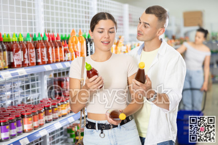 Man and woman couple choosing chili sauce