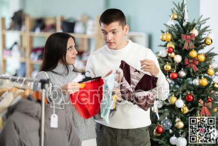 Couple chooses lingerie for girl in a clothing store during Christmas celebrations.