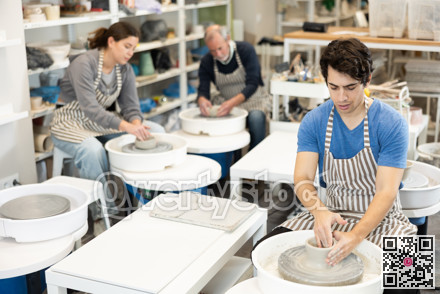 Guy potter works on potter wheel to create clay cup