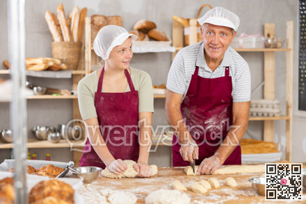 Elderly man and girl make dough, employee kneads dough, assistant cuts dough into portions