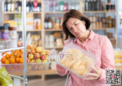 Mature woman choosing chicken in grocery store