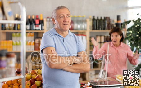 Family quarrel between elderly husband and wife in grocery supermarket. Woman screams at her husband