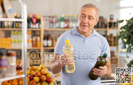 Mature man choosing vegetable oil in grocery store