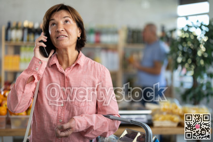 Elderly woman choosing groceries while talking on phone