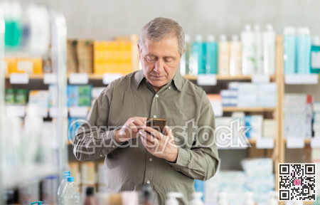 Senior man with phone is shopping in pharmacy