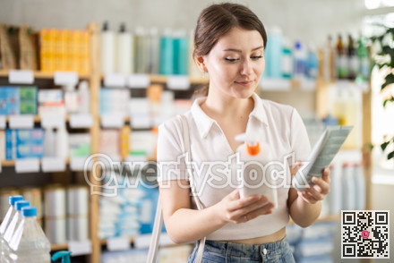 Young woman choosing a cream in a pharmacy