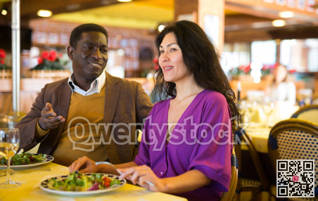 Positive man and woman in restaurant with alcohol drinks