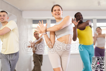 European girl with team of like-minded multinational people learn to elements of electro dance