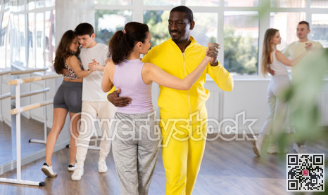 Club for those who like to dance for their own pleasure, non-professional dance performers enjoy waltz during rehearsal in dance studio