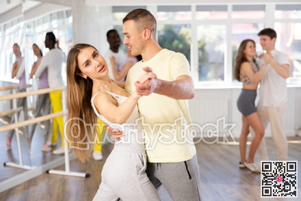 Couple in sportswear rehearsing waltz at group dance class