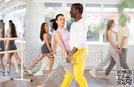 African American practicing bachata with brunette in dance class