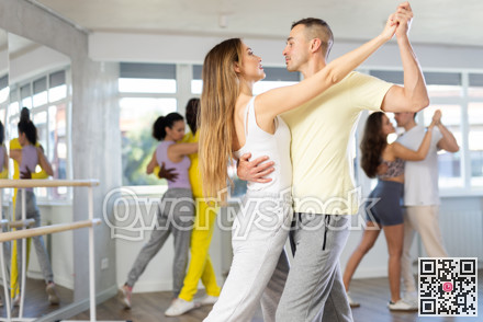 Man and young woman dancing waltz in couple during lesson at studio