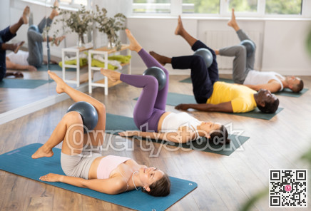 Group of men and women doing pilates with softball