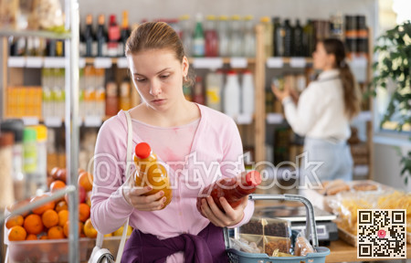 woman chooses juices against the background of buyers