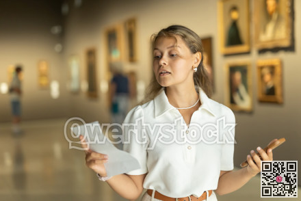 Woman with phone in hands view pictures and icons in museum hall
