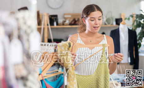 Fashionista girl near showcase examine goods, buying something clothing for summer.