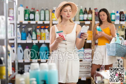 Woman consumer choose razor in household supermarket, while in background shoppers browse products