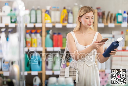 Girl buyer scans qr code on glass cleaner spray label