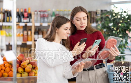 Mom and daughter scanning packages of hamburger patties