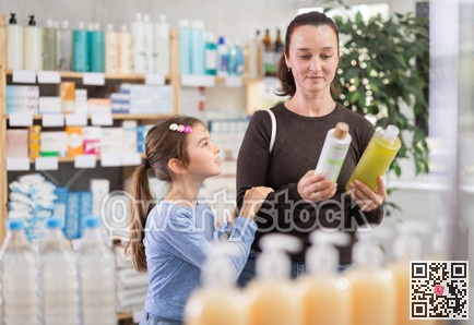 Woman with schoolgirl daughter are busy choosing shampoo at pharmacy