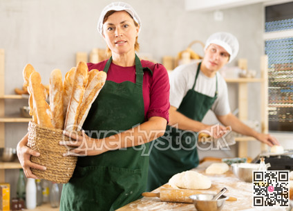 Adult woman baker with basket of baguettes