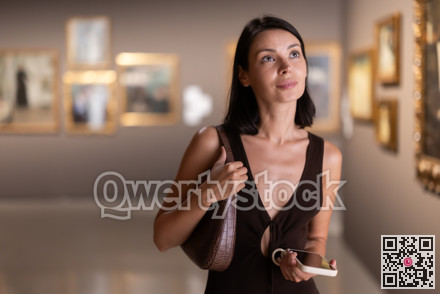 Brunette with phone in hand came to the art gallery