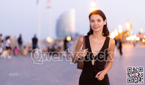 Young woman walking on a lively promenade of Barceloneta