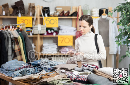Woman chooses fashionable trousers for autumn winter season in store