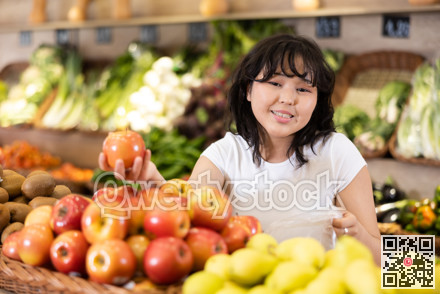 Delighted young woman purchaser choosing apples in grocery store