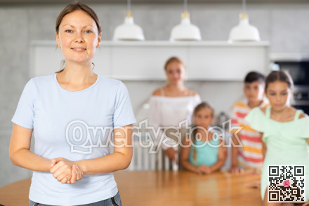 Portrait of happy mother of large family against the background of children and his wife in the interior of house