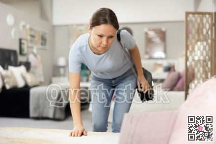 Positive woman chooses modern sofa in furniture store