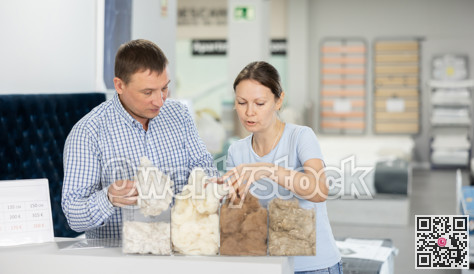 Couple examines samples of mattress fillers in furniture store