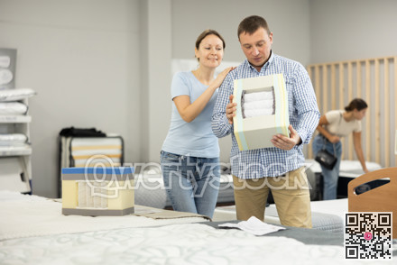 Married couple chooses and discusses mattress filling in furniture store